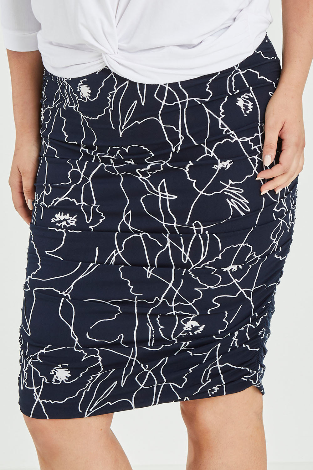 Model Jess wearing size 12 of the Belle Monoprint Side Gathers Skirt in colour Monoprint (Blue), from the front, cropped image