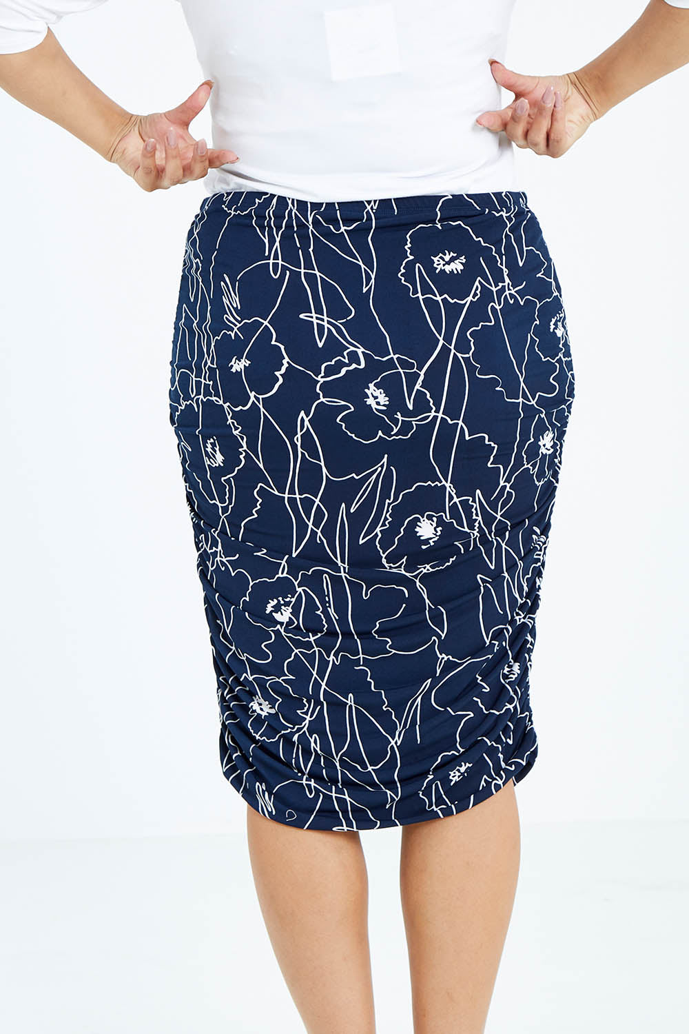 Model Sasha-Lee wearing size 16 of the Belle Monoprint Side Gathers Skirt in colour Monoprint (Blue), from the back