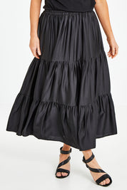 Model Laura wearing size 10 of the Belle Slinky Tiered Skirt in colour Black (Black), from the front, cropped image
