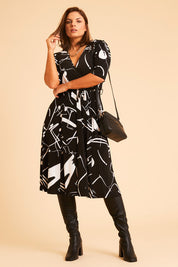Model Monique wearing size 14 of the Belle X Over Full Skirt Dress in colour Blackwhite (Black), from the front, showing the whole outfit