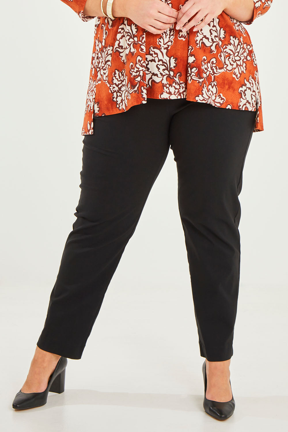 Model Caitlin wearing size 20 of the Belle Essential Pull On Slim Leg Pant in colour Black (Black), from the front, cropped image