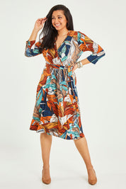 Model Terri-Leigh wearing size 14 of the Belle Faux Long Sleeve Wrap Dress in colour Leafprint (White), from the front, showing the whole outfit