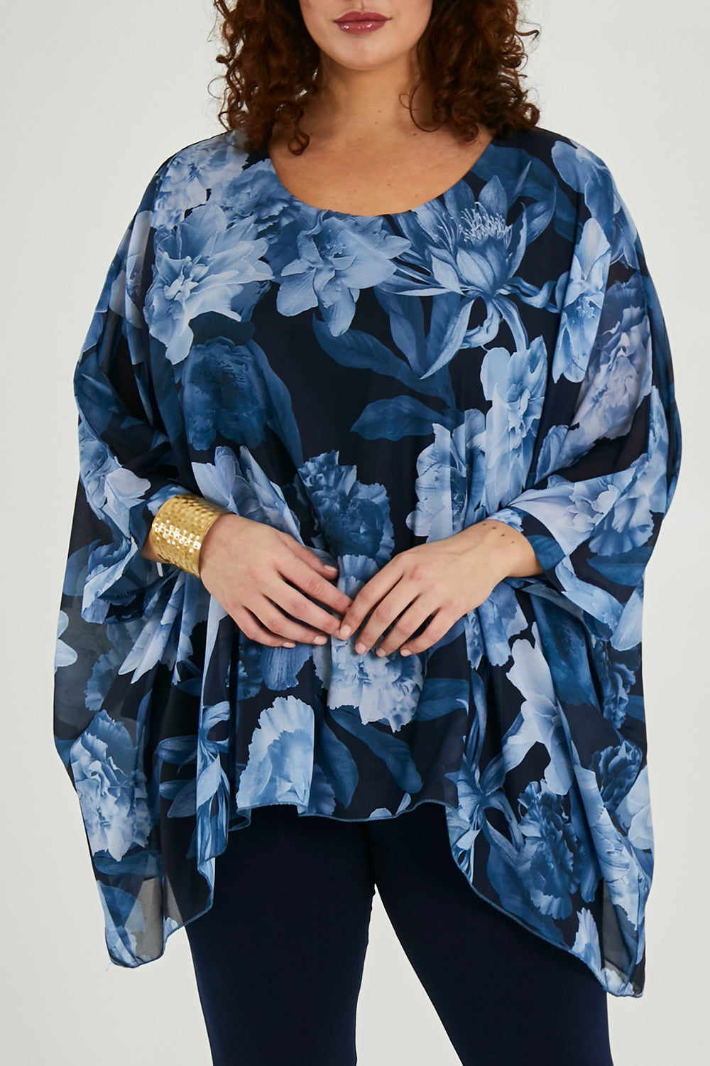 Model Maddy wearing size 16 of the Belle Chiffon Overlay Top in colour Bluefloral (Blue), from the front, cropped image