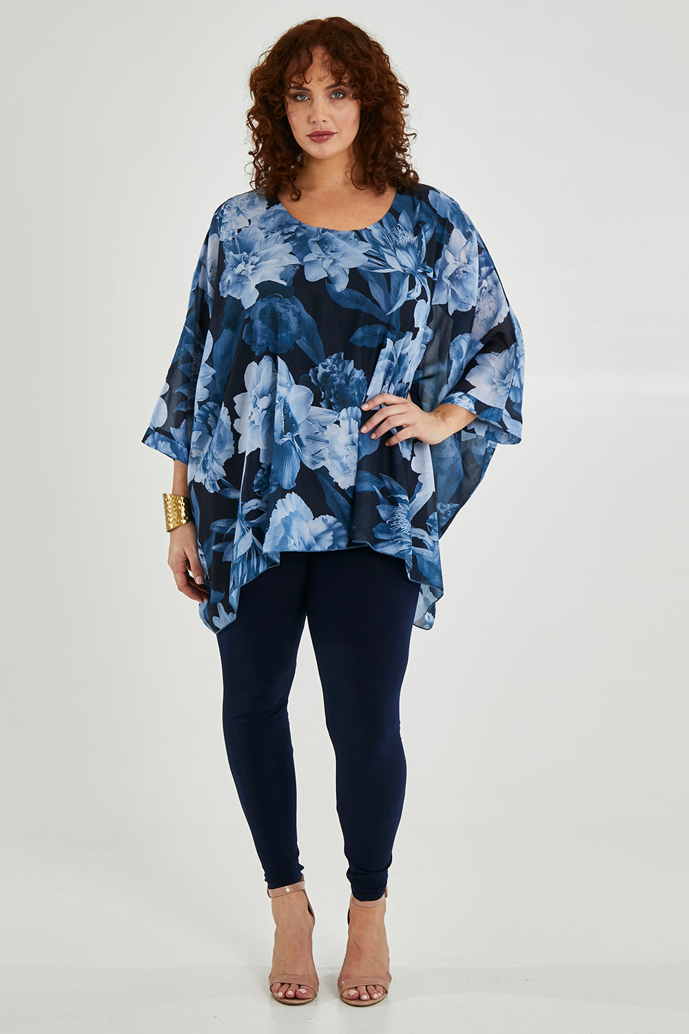 Model Maddy wearing size 16 of the Belle Chiffon Overlay Top in colour Bluefloral (Blue), from the front, showing the whole outfit