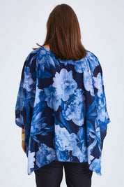 Model Monique wearing size 14 of the Belle Chiffon Overlay Top in colour Bluefloral (Blue), from the back