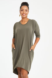 Model Noli wearing size 14 of the Belle High Low Easy Wear Dress in colour Khaki (Green), from the front, cropped image