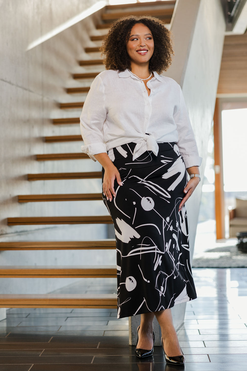 Model Alexis wearing size 18 of the Belle Fit & Flare Printed Skirt in colour Blackwhite (Black), from the front, showing the whole outfit