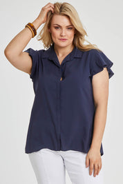Model Keeara wearing size 16 of the Belle Flutter Sleeve Shirt in colour Navy (Blue), from the front, cropped image