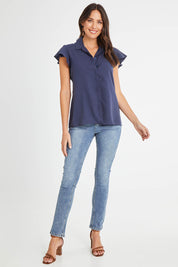 Model Madeline wearing size 10 of the Belle Flutter Sleeve Shirt in colour Navy (Blue), from the front, showing the whole outfit