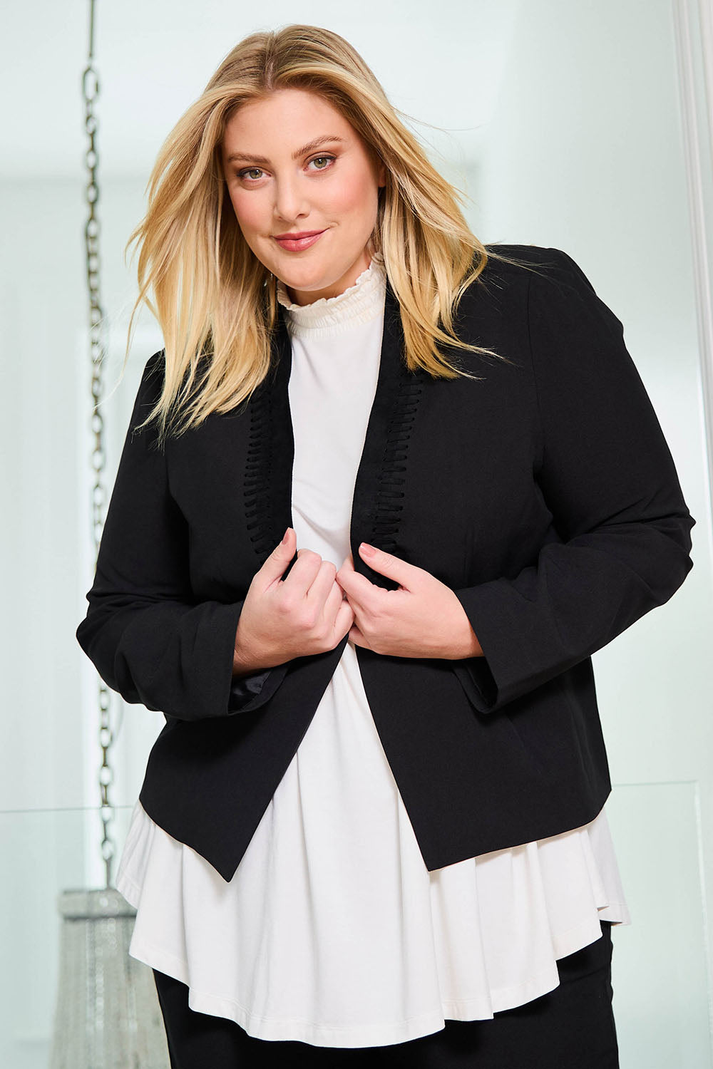 Model Caitlin wearing size 18 of the Belle Eyelet Detail Blazer in colour Black (Black), from the front, showing the whole outfit