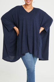 Model Noli wearing size 14 of the Belle Rib Knit Throw Over in colour Navymarle (Blue), from the front, cropped image