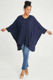 Model Noli wearing size 14 of the Belle Rib Knit Throw Over in colour Navymarle (Blue), from the front, showing the whole outfit