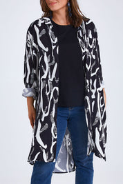 Model Monique wearing size 14 of the Belle Relaxed Long Printed Shirt in colour Blackivory (Black), from the front, cropped image