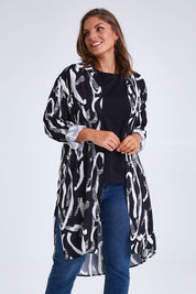 Model Monique wearing size 14 of the Belle Relaxed Long Printed Shirt in colour Blackivory (Black), from the front, cropped image