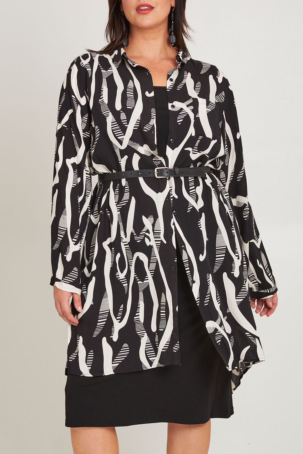 Model Poppy wearing size 16 of the Belle Relaxed Long Printed Shirt in colour Blackivory (Black), from the front, cropped image