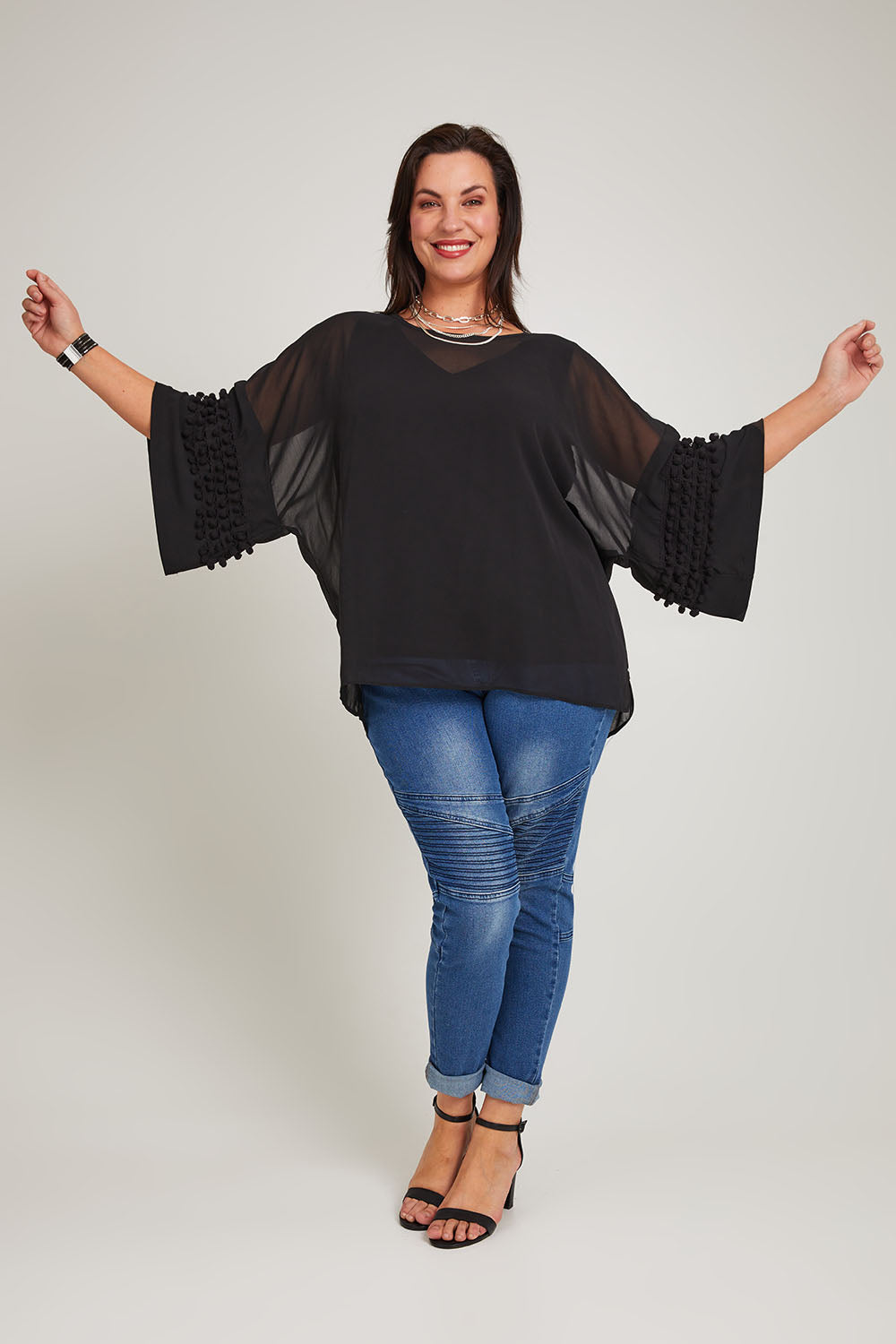 Model Poppy wearing size 16 of the Belle Chiffon Bubble Detail Top w/Cami in colour Black (Black), from the front, showing the whole outfit
