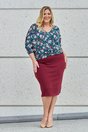 Model Caitlin wearing size 18 of the Belle Textured Pull On Skirt in colour Cranberry (Red), from the front, showing the whole outfit