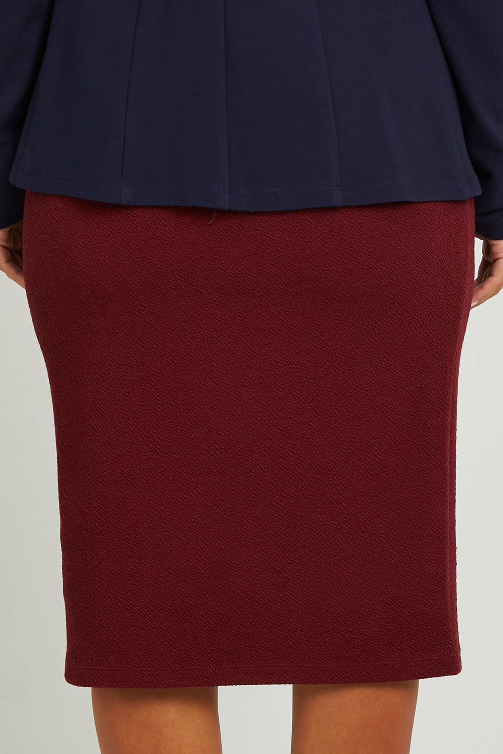 Model Monique wearing size 14 of the Belle Textured Pull On Skirt in colour Cranberry (Red), from the back