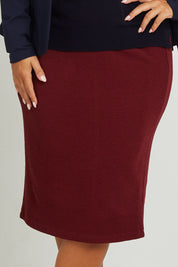 Model Monique wearing size 14 of the Belle Textured Pull On Skirt in colour Cranberry (Red), from the front, cropped image