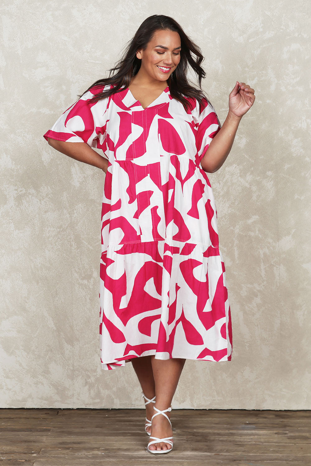 Model Ashleigh wearing size 16 of the Belle V Panel Tier Dress in colour Pinksorbet (Pink), from the front, showing the whole outfit