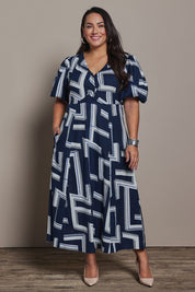 Model Ashleigh wearing size 16 of the Belle Printed Twist Knot Detail Cotton Dress in colour Bluegeo (Blue), from the front, showing the whole outfit