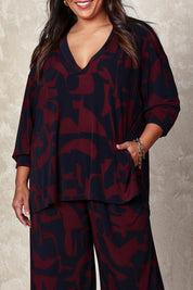 Model Ashleigh wearing size 16 of the Belle Easywear V Neck Pop Over Top in colour Winenavy (Blue), from the front, cropped image