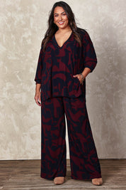 Model Ashleigh wearing size 16 of the Belle Easywear V Neck Pop Over Top in colour Winenavy (Blue), from the front, showing the whole outfit