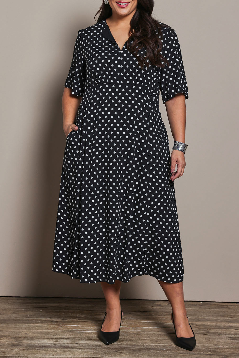 Model Ashleigh wearing size 16 of the Belle Fluted A Line Dress With Pockets in colour Blackwhite (Black), from the front, cropped image