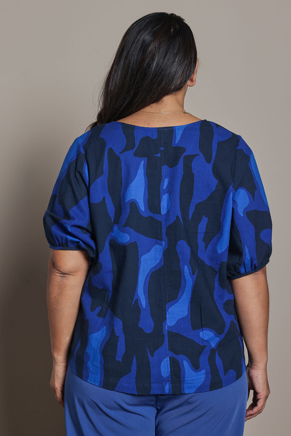 Model Ashleigh wearing size 16 of the Belle Cotton Printed V Neck Top in colour Trioofblue (Blue), from the back