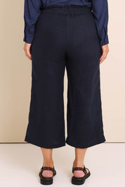 Model Lauraw wearing size 14 of the Belle Easy Wear Linen Pant – Navy in colour Navy, from the back