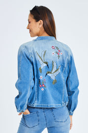 Model Cara wearing size 10 of the Give Me Wings Denim Jacket in colour Denim (Blue), from the back