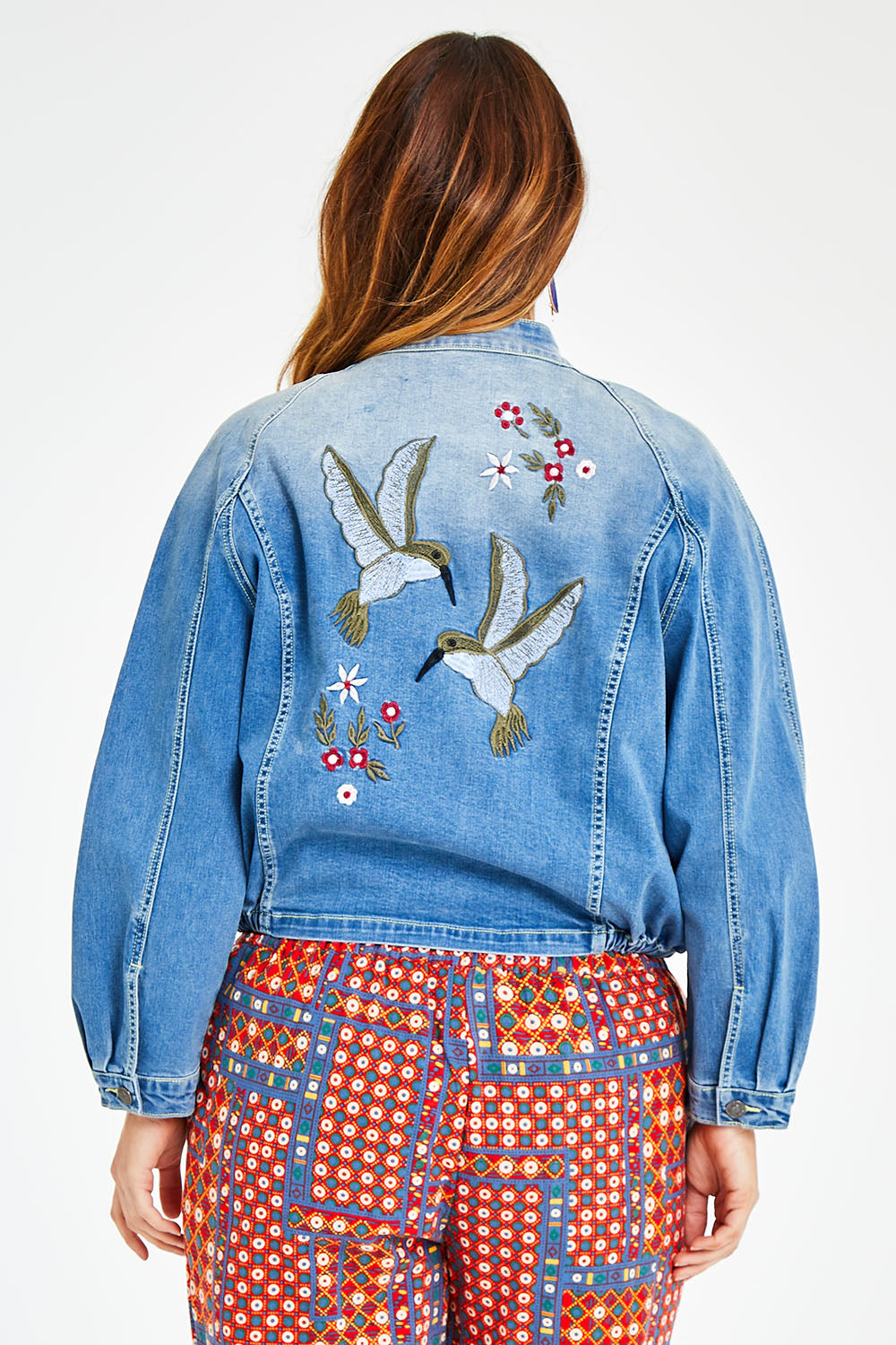 Model Laura wearing size 14 of the Give Me Wings Denim Jacket in colour Denim (Blue), from the back