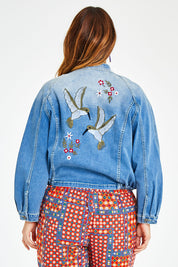 Model Laura wearing size 14 of the Give Me Wings Denim Jacket in colour Denim (Blue), from the back