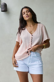 Model Tahnee wearing size 10 of the Cute As A Button Blouse in colour Blush (Pink), from the front, showing the whole outfit