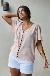 Model Tahnee wearing size 10 of the Cute As A Button Blouse in colour Blush (Pink), from the front, showing the whole outfit
