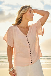 Model Tegan wearing size 10 of the Cute As A Button Blouse in colour Blush (Pink), from the front, showing the whole outfit