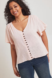 Model Terri-Leigh wearing size 14 of the Cute As A Button Blouse in colour Blush (Pink), from the front, cropped image