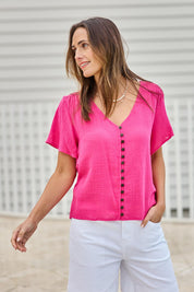 Model Tegand wearing size 10 of the Cute As A Button Blouse - Hotpink in colour Hotpink, in a cropped view