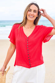 Model Tegan wearing size 10 of the Cute As A Button Blouse in colour Red (Red), from the front, showing the whole outfit