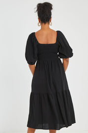 Model Noli wearing size 14 of the Wandering In Fields Organic Cotton Dress in colour Black (Black), from the back