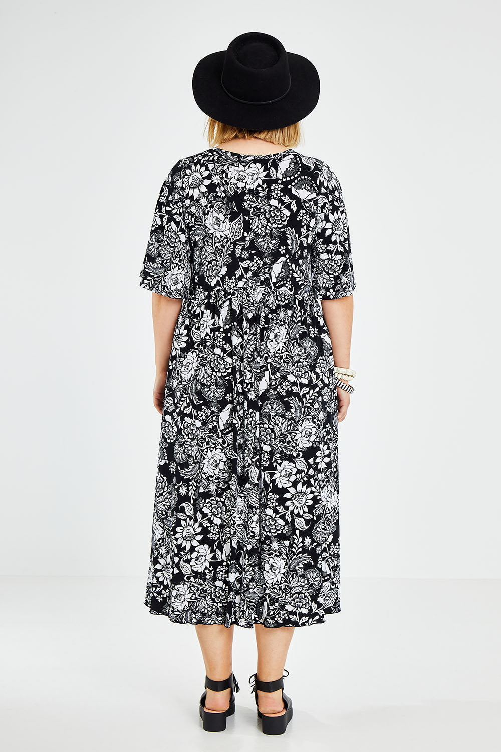 Model Jess wearing size 14 of the Swinging Hands With You Dress in colour Blackfleur (Black), from the back