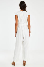 Model Vitoria wearing size 10 of the I See You Jumpsuit in colour Ivory (White), from the back