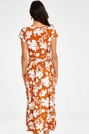 Model Vitoria wearing size 10 of the Feels Like Summer Wrap Dress in colour Rust, from the back