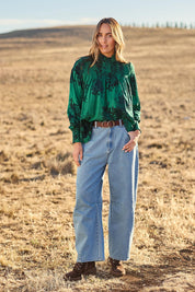 Model Tegan wearing size 10 of the Romance In The Air Blouse in colour Emerald (Green), from the front, showing the whole outfit
