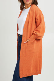 Model Monique wearing size L of the A True Jewel Cardi in colour Rust, from the front, cropped image