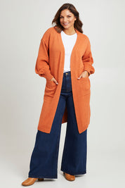 Model Monique wearing size L of the A True Jewel Cardi in colour Rust, from the front, showing the whole outfit