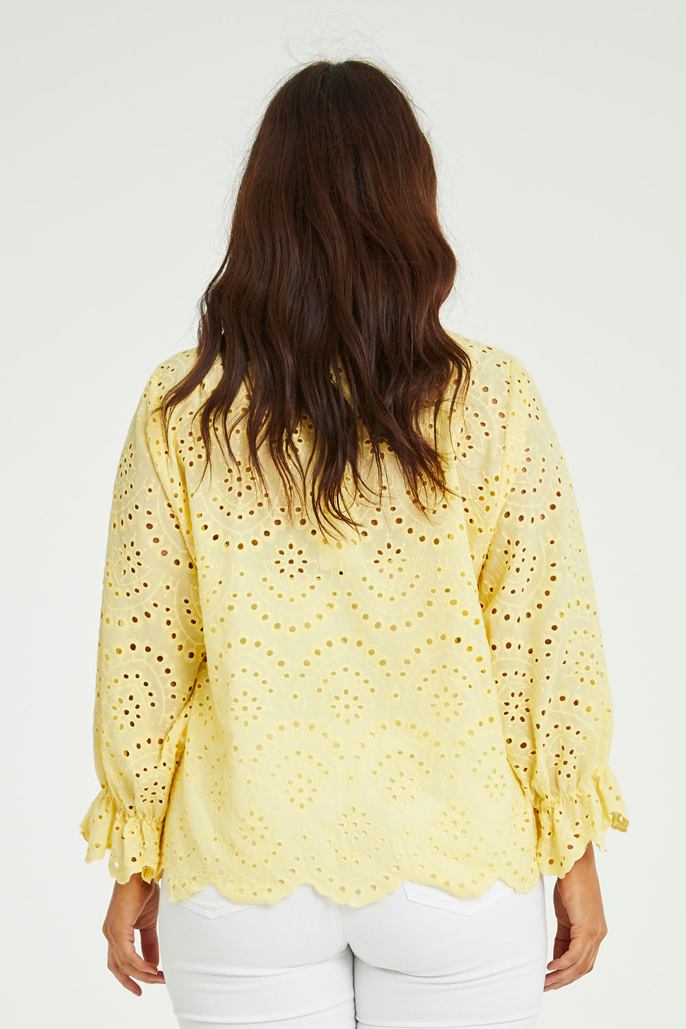 Model Laura wearing size 14 of the Sweet Pea Broderie Blouse in colour Sun, from the back