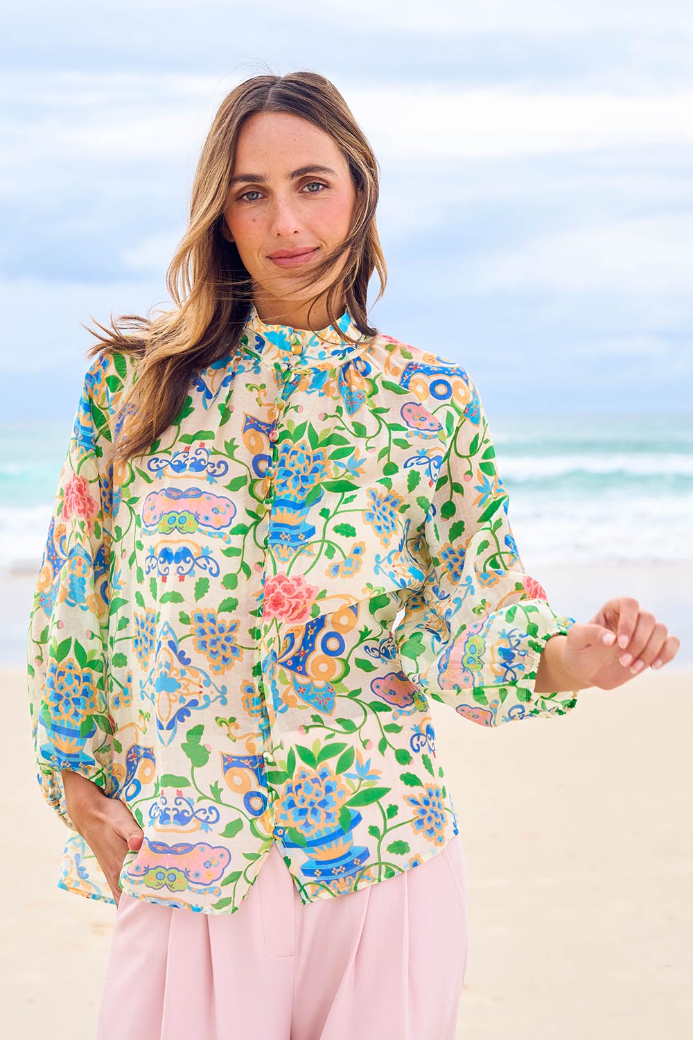 Model Tegan wearing size 10 of the High Tea Garden Party Blouse in colour Garden, from the front, showing the whole outfit