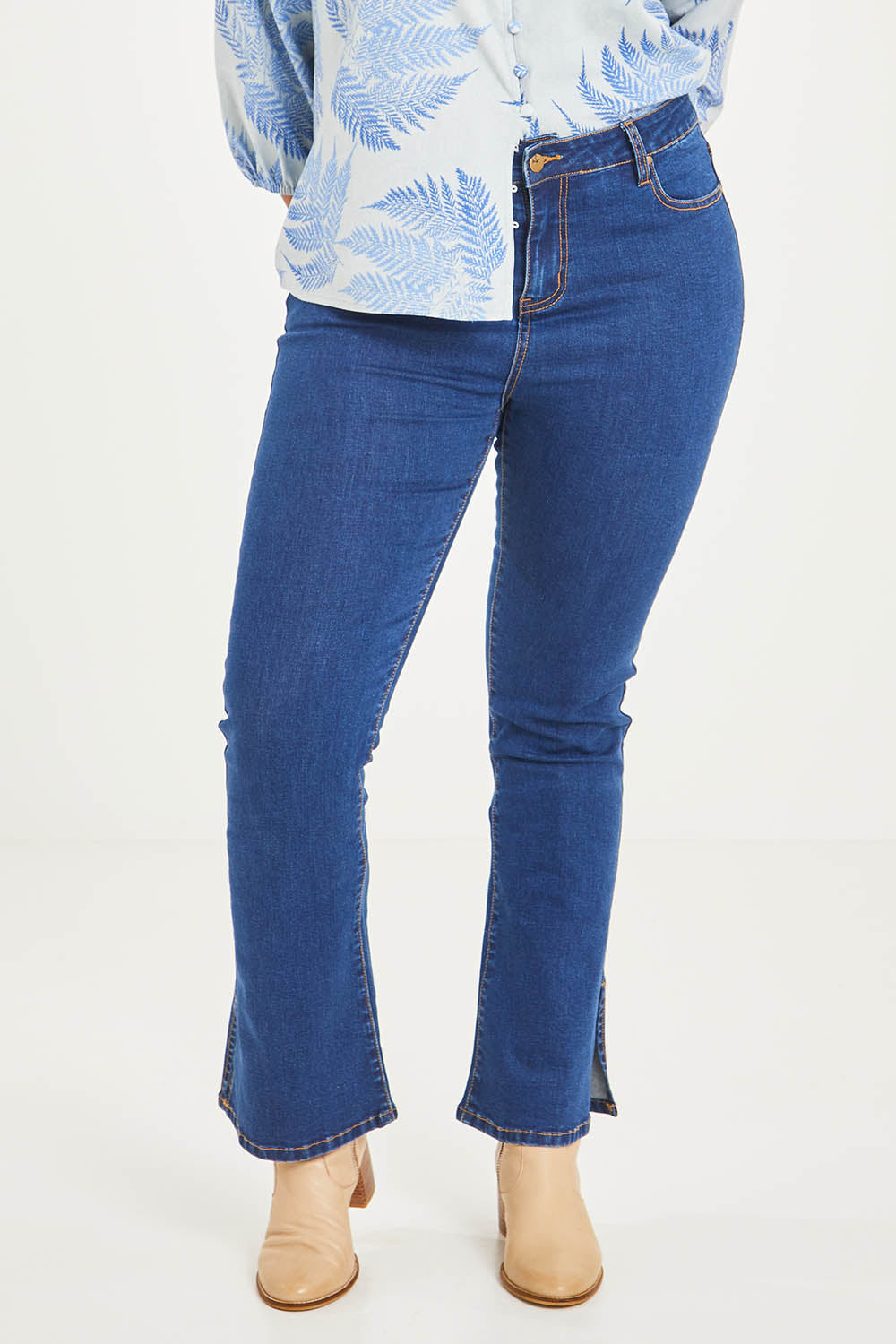 Model Noli wearing size 14 of the Shaking My Tail Feather Flared Jeans in colour Indigo (Blue), from the front, cropped image