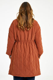 Model Laura wearing size 14 of the Heart Warming Quilted Anorak in colour Rust, from the back